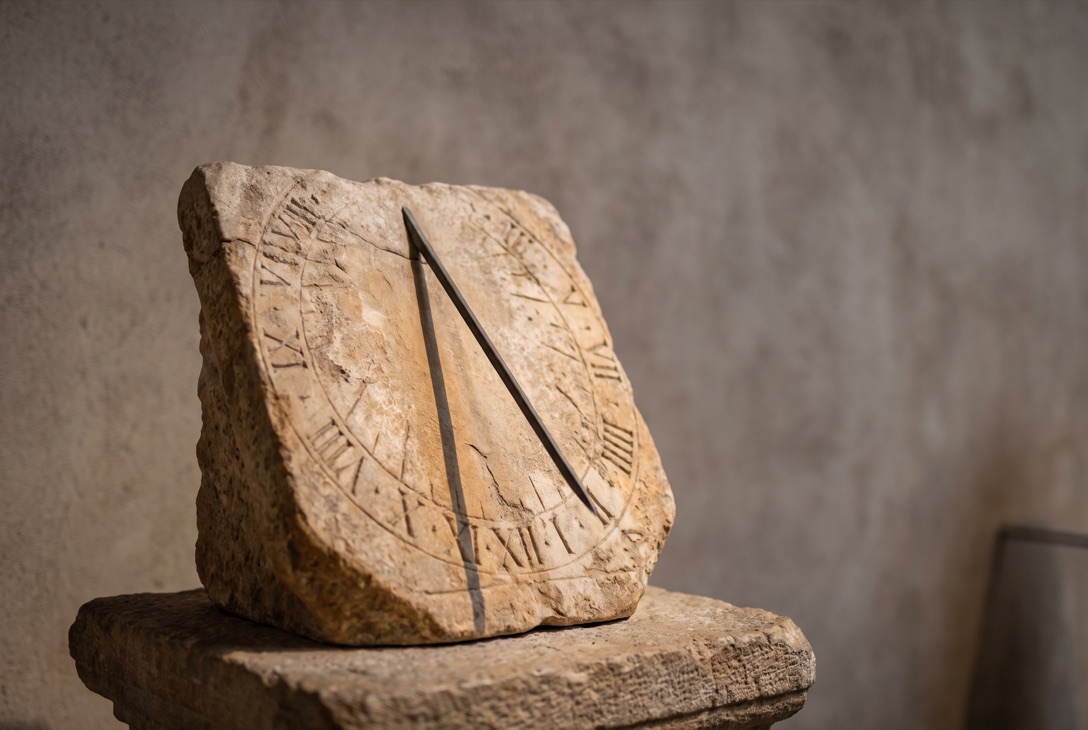 A weathered marble sundial in raking light